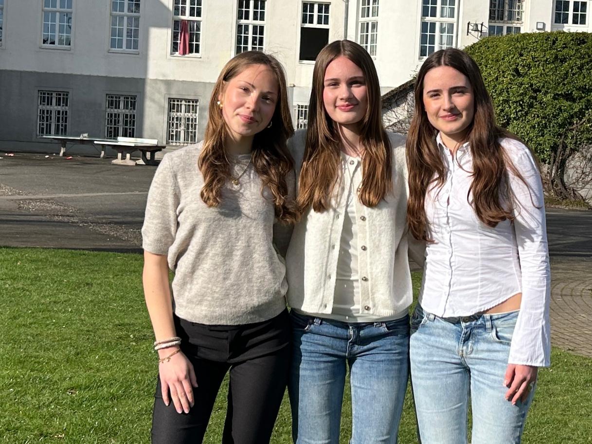 drei Mädchen vor dem Schulgebäude