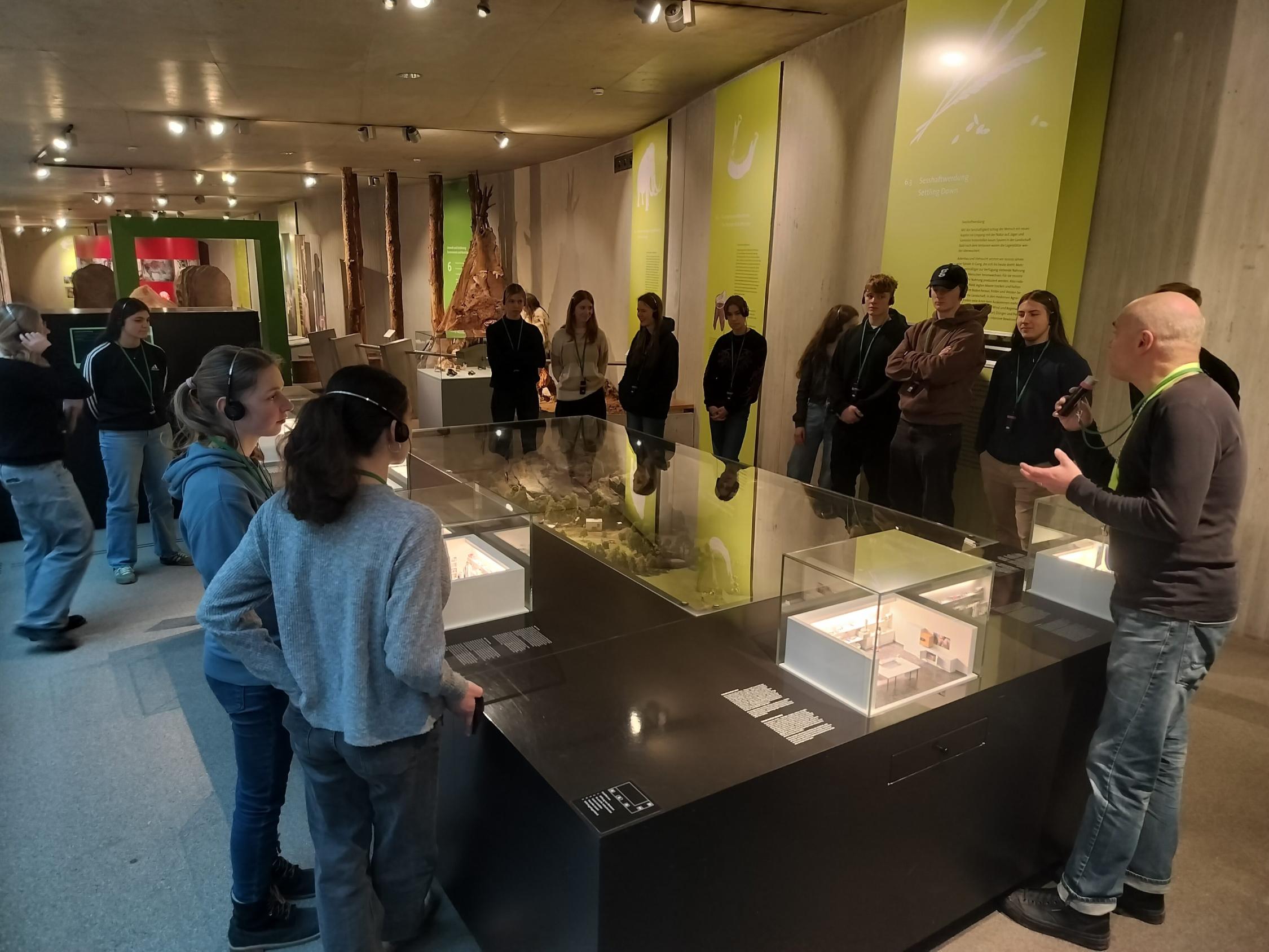 Schülerinnen und Schüler stehen um einen großen Schaukasten