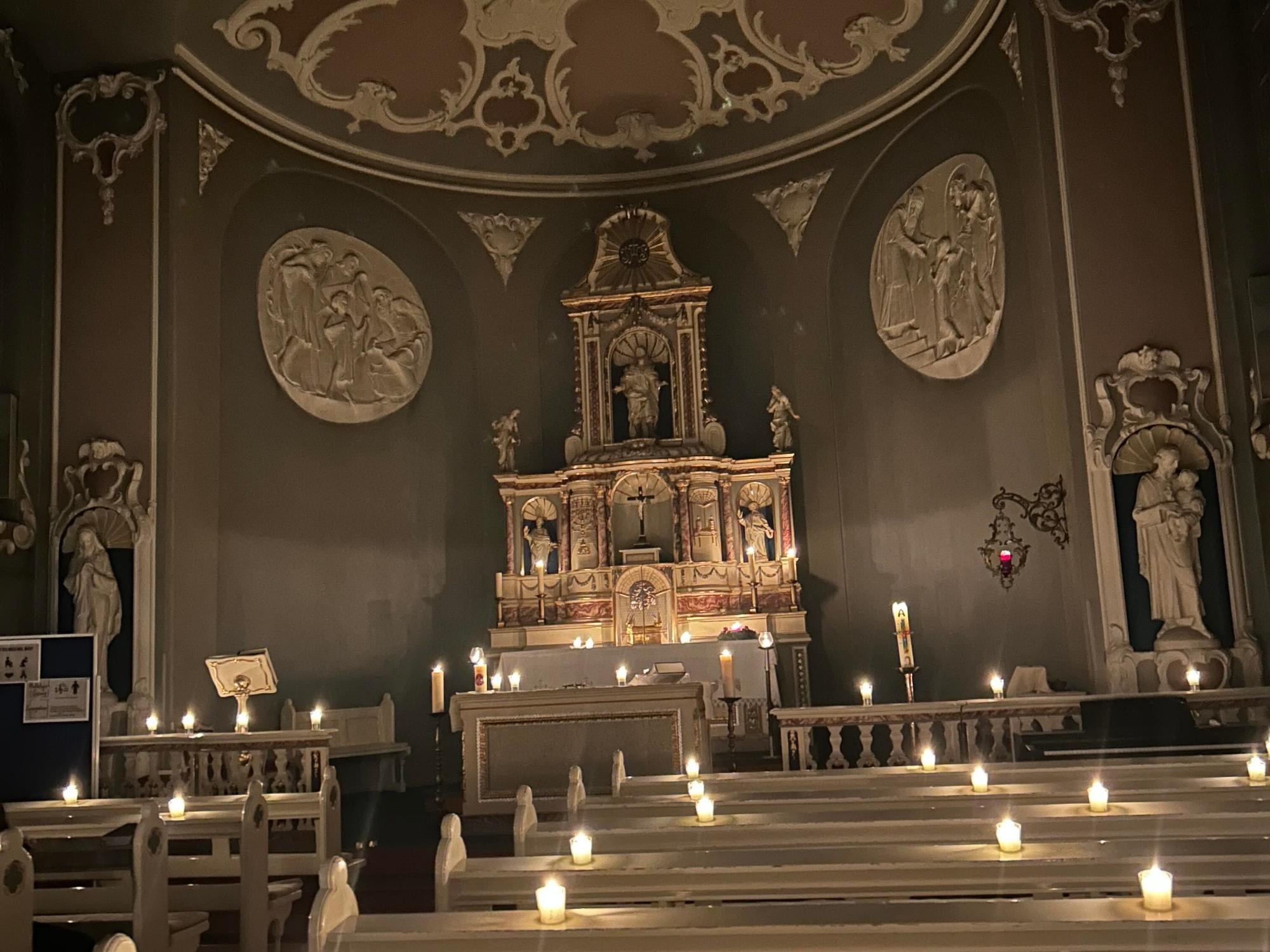 Schulkapelle mit vielen brennenden Kerzen