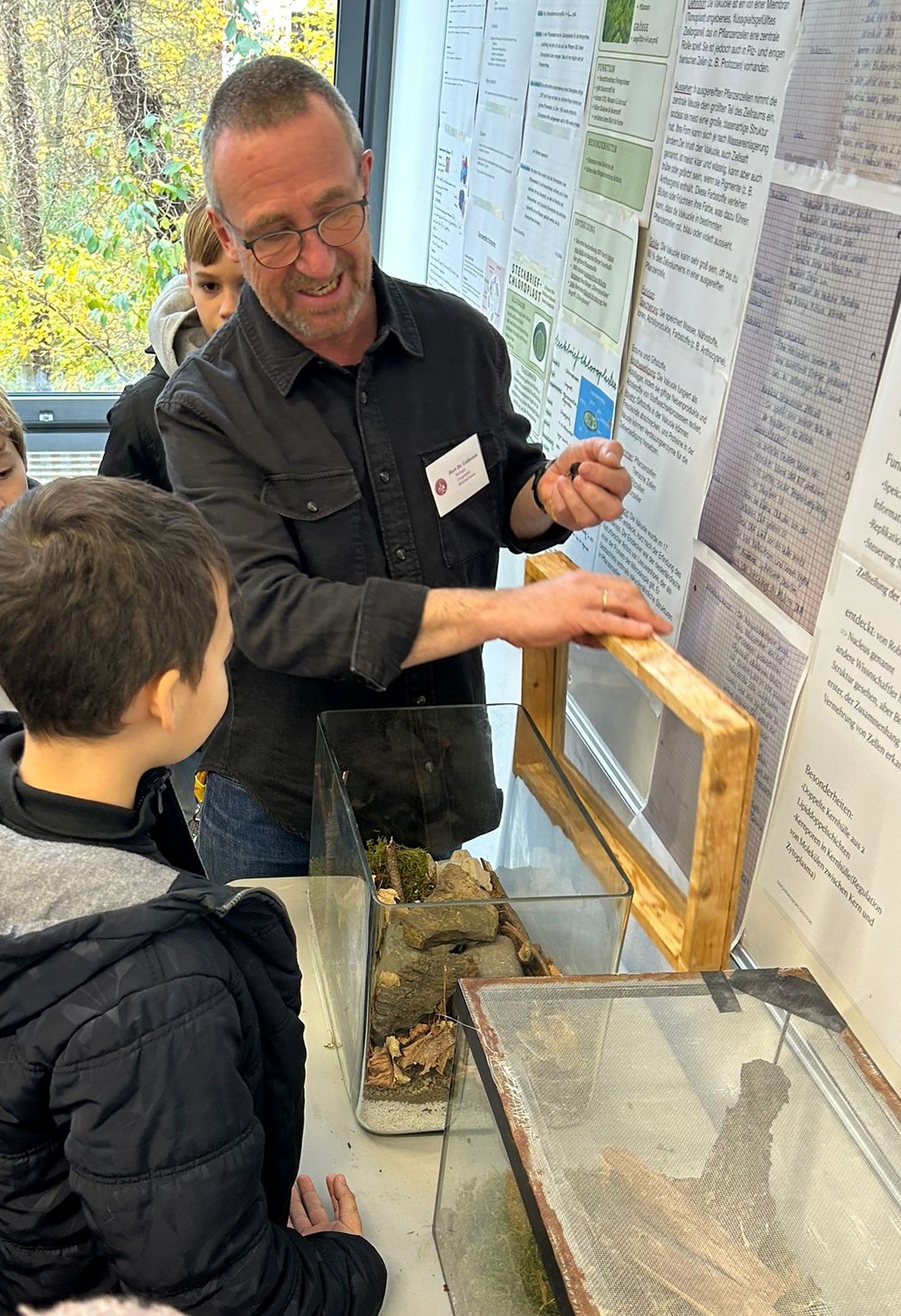 Lehrer zeigt Kindern ein Terrarium