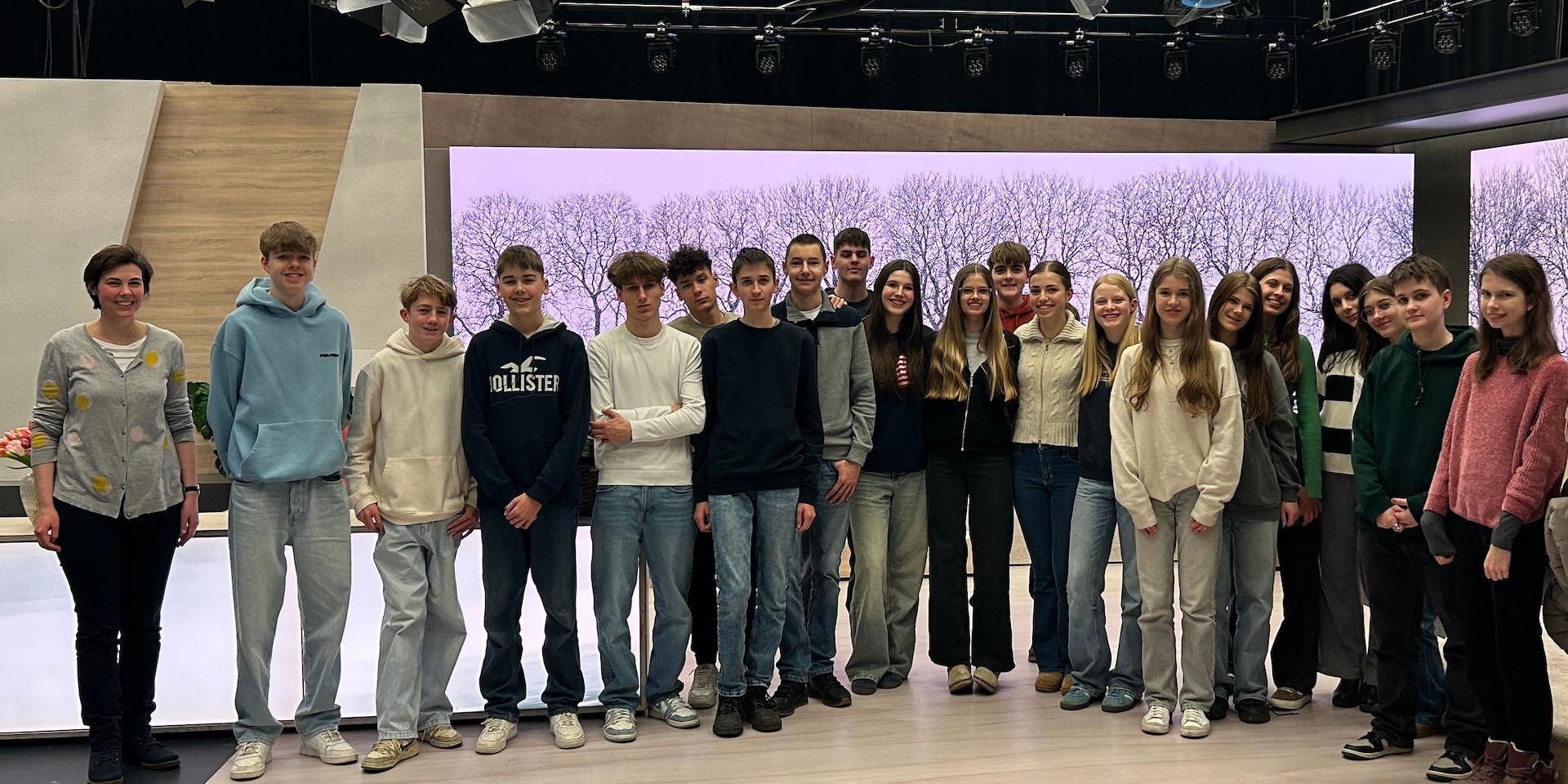 Schüler:innen und Lehrerin in einem Fernsehstudio (Gruppenbild)