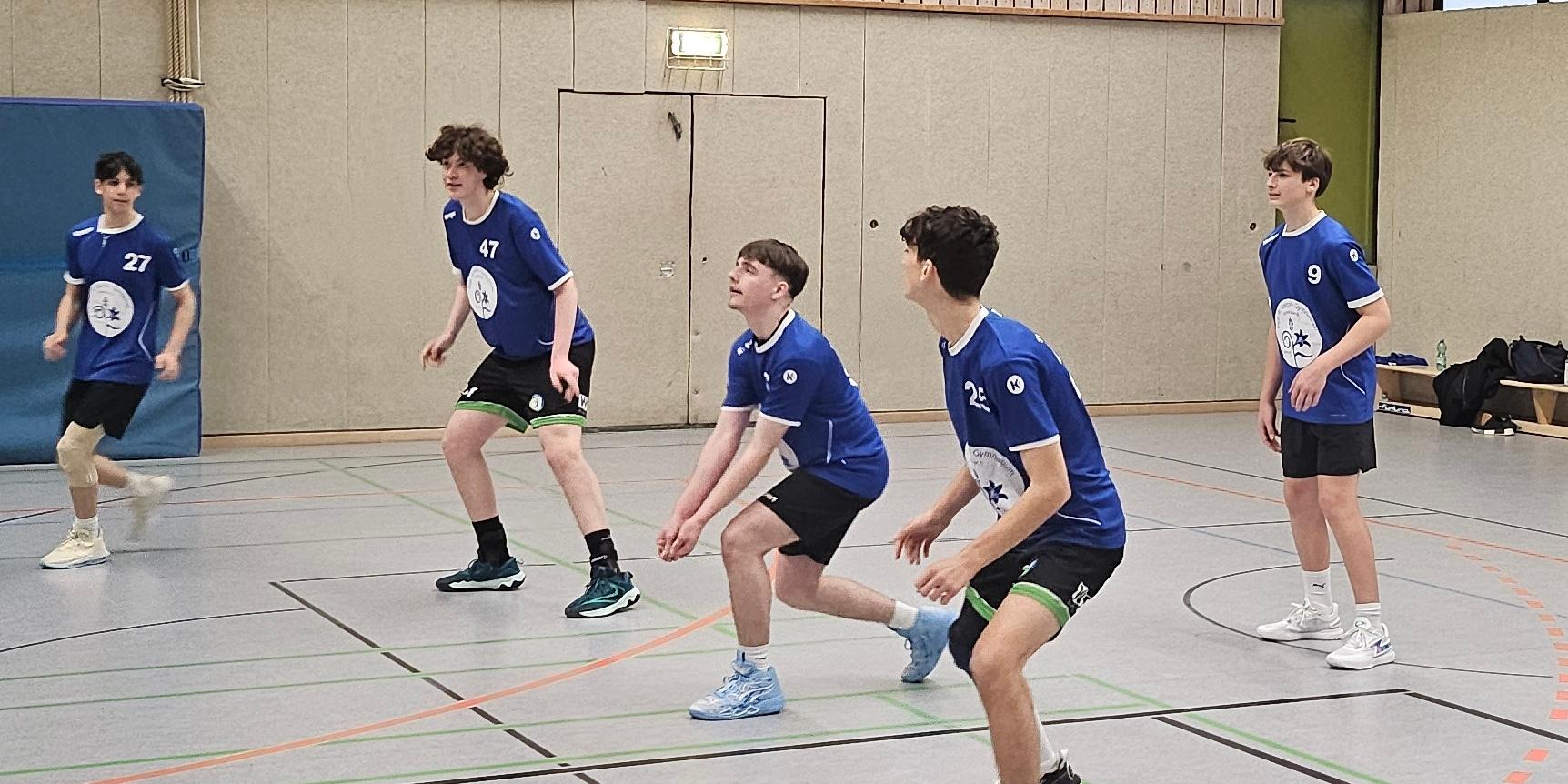 Jungen spielen Volleyball, einer springt hoch