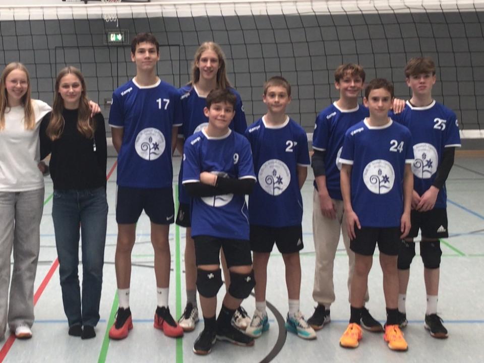 Gruppenfoto mit Jungenmannschaft in der Sporthalle, daneben Mädchen (als Schiedsrichterinnen)